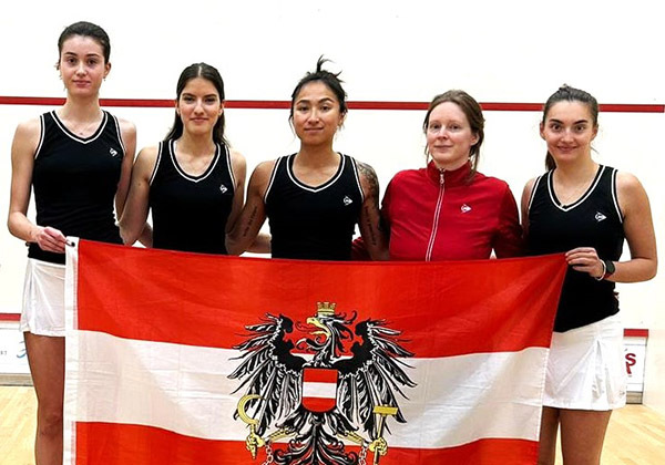 Fünf Frauen posieren hinter einer Österreich-Flagge